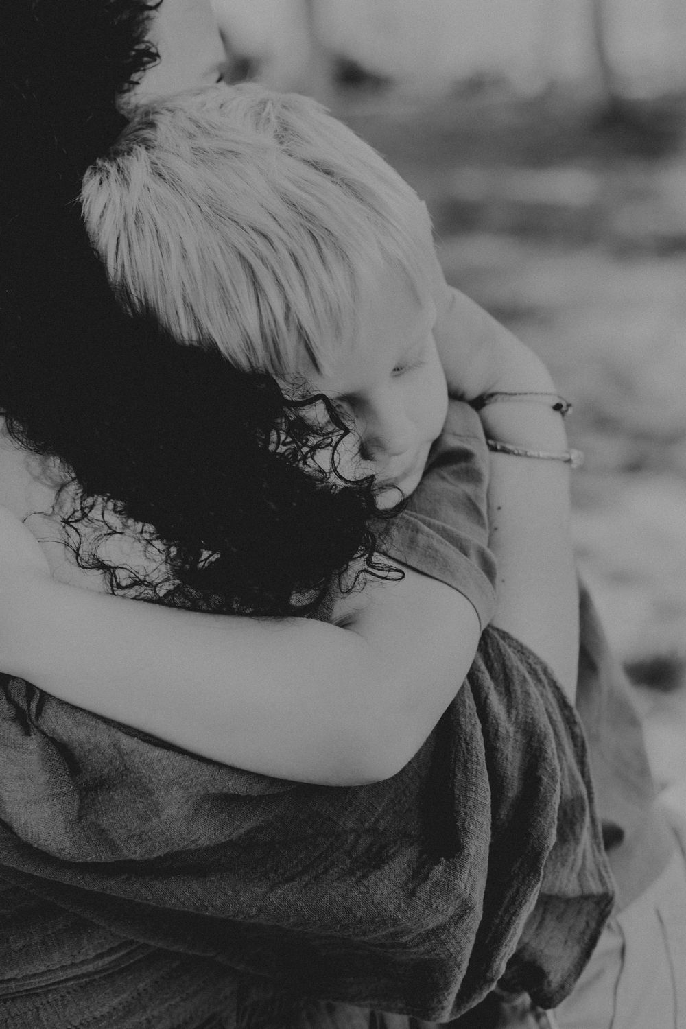 A black and white photo series showing a person in glasses hugging and nuzzling a dog in an intimate, tender moment.