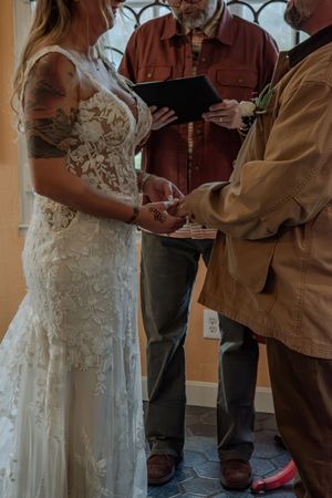 Wedding ceremony preparations showing white lace dress and casual attire indoors.