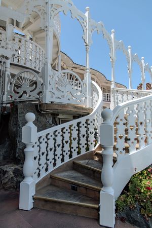 Ornate white Victorian staircase with intricate decorative railings and architectural details in vintage style.