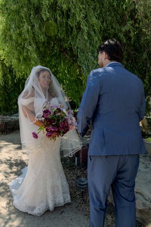 Wedding couple poses for romantic outdoor photos in garden setting.