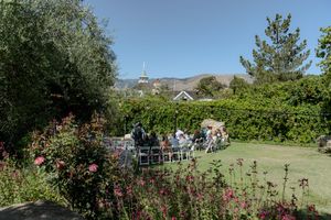 Scenic outdoor wedding venue with mountain views, green landscaping and blooming rose bushes.
