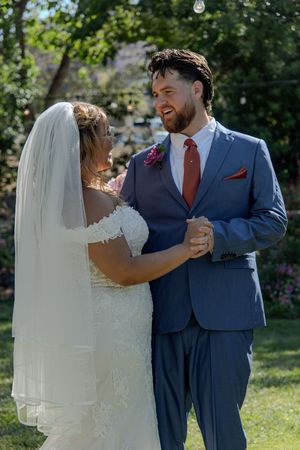 A couple shares an intimate moment during their outdoor garden wedding celebration.