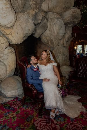 Couple shares intimate moment in unique cave-like setting with colorful decor.
