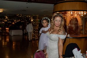 Wedding reception scene in a dimly lit venue decorated with warm glowing lights.