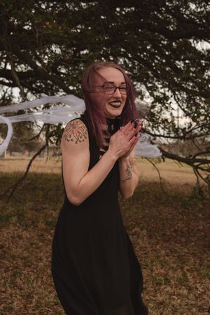 A sequence of candid shots shows someone in a black sleeveless top laughing joyfully outdoors under tree branches.