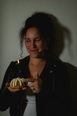 A sequence of dark moody photos showing someone lighting and blowing out a birthday candle in dramatic shadows.