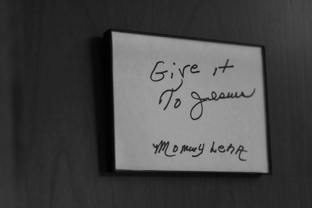 A black and white photo shows handwritten text that reads 'Give it to Joanne' in a dark frame.