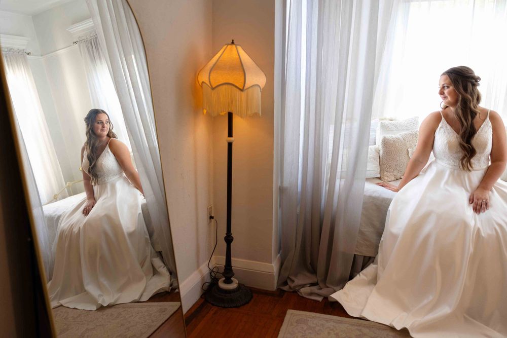 Bridal portraits in a light-filled room with a floor-length white gown and vintage floor lamp.