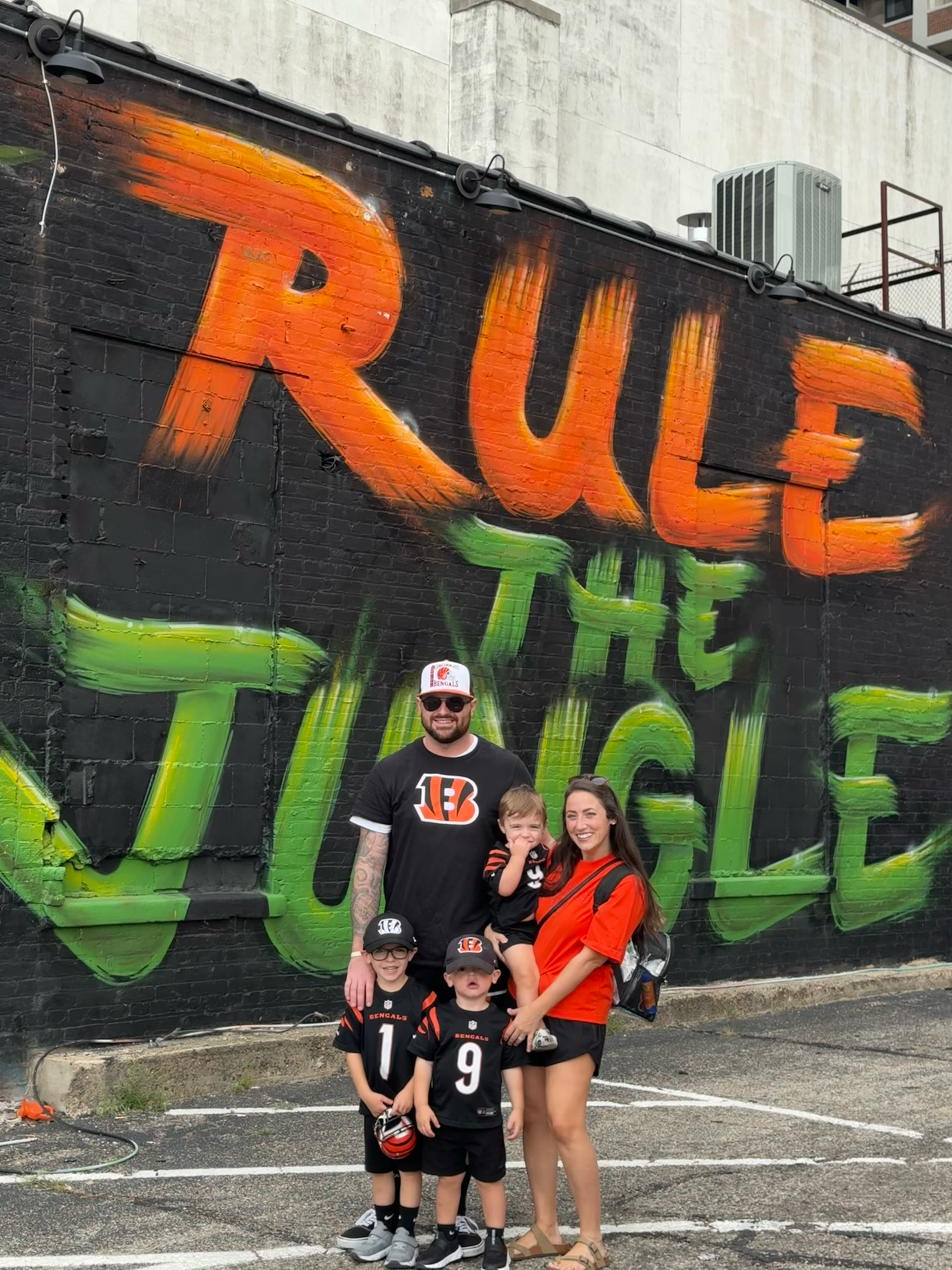 Cincinnati Bengals fans in orange and black team gear show support while enjoying a game at the stadium.