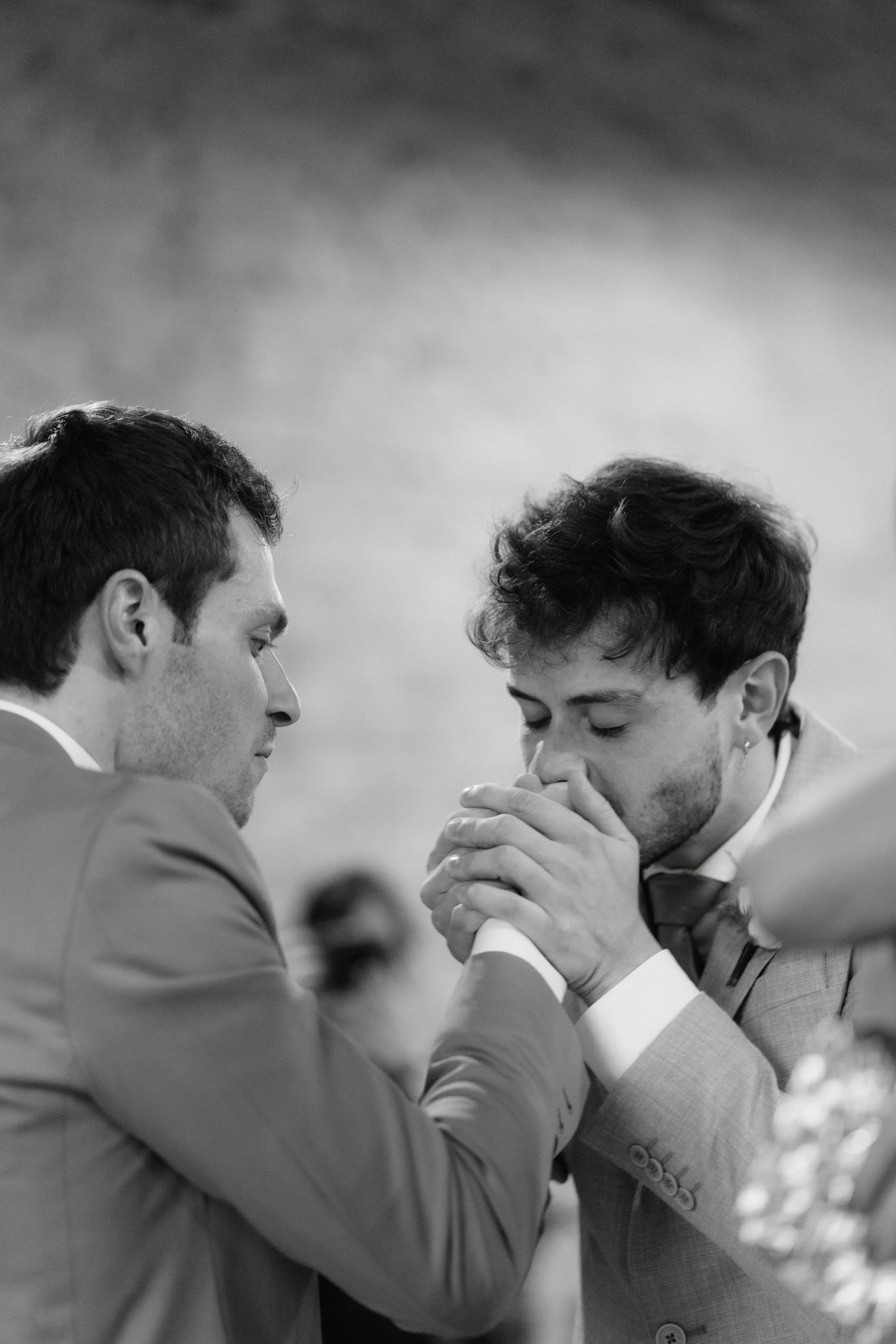 An intimate black and white moment shared between two people during wedding celebrations.