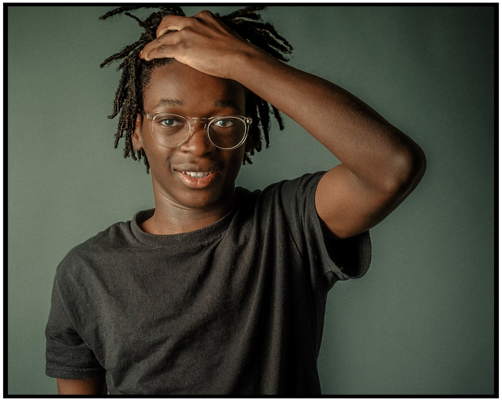 Natural lifestyle portrait with glasses against a green studio background. Portland portrait photographer