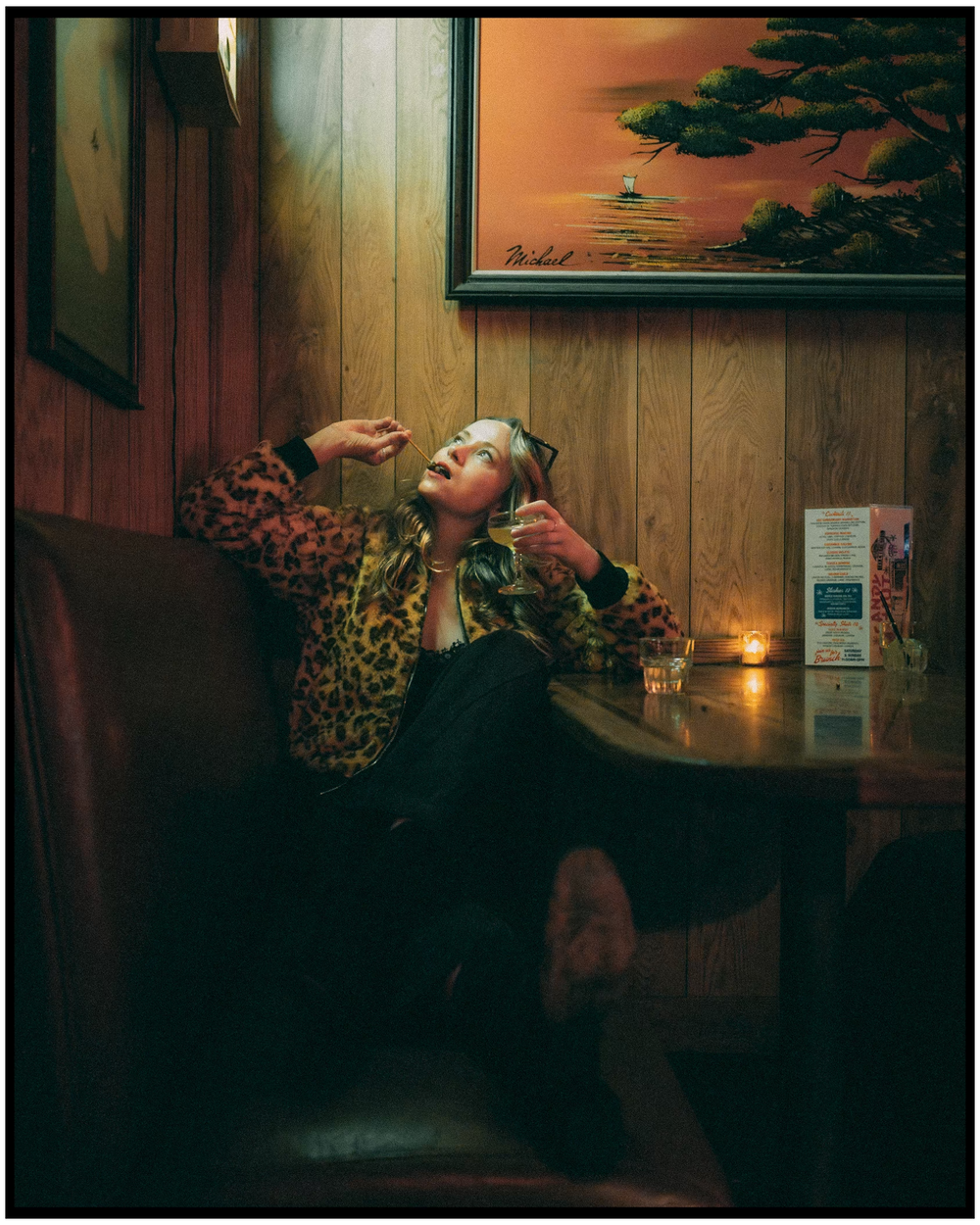 Atmospheric nighttime scene in a wood-paneled room with vintage decor and moody lighting. Portland portrait photographer