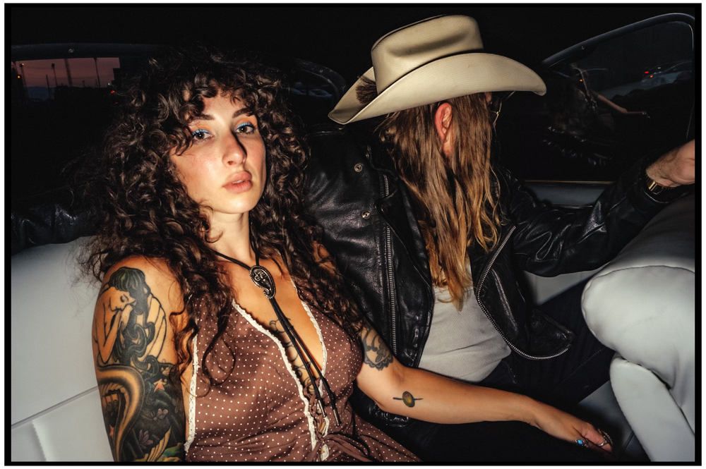 Candid shot of passengers with tattoos and cowboy hat riding in car backseat. Portland portrait photographer