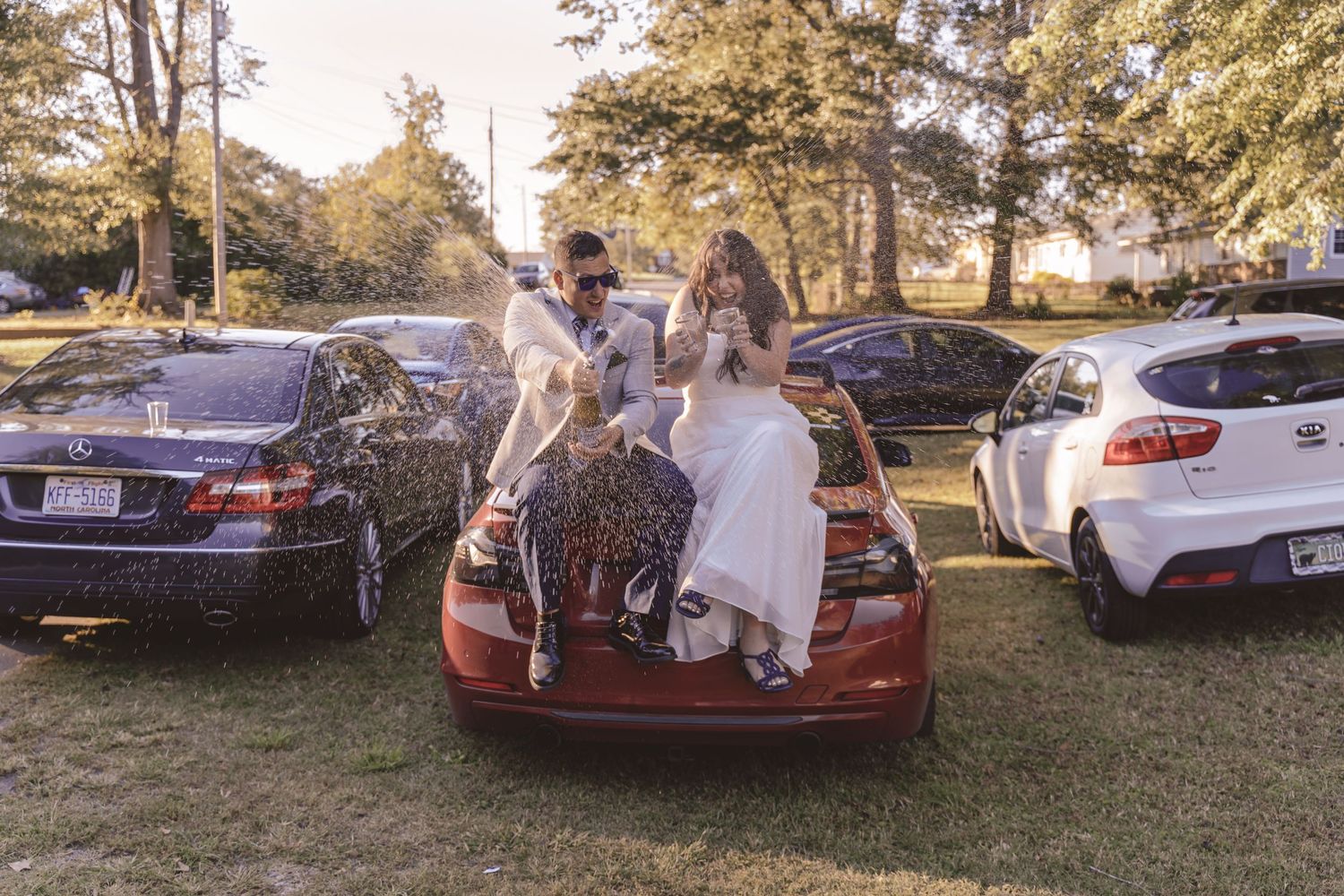 Newlyweds spraying champagne at an intimate backyard wedding at a private residence in North Carolina