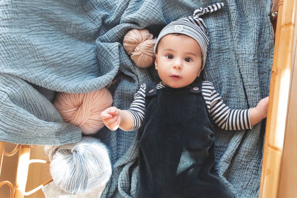 Fotografía de moda bebé acostado en cuna con ropa de BEANS en Barcelona