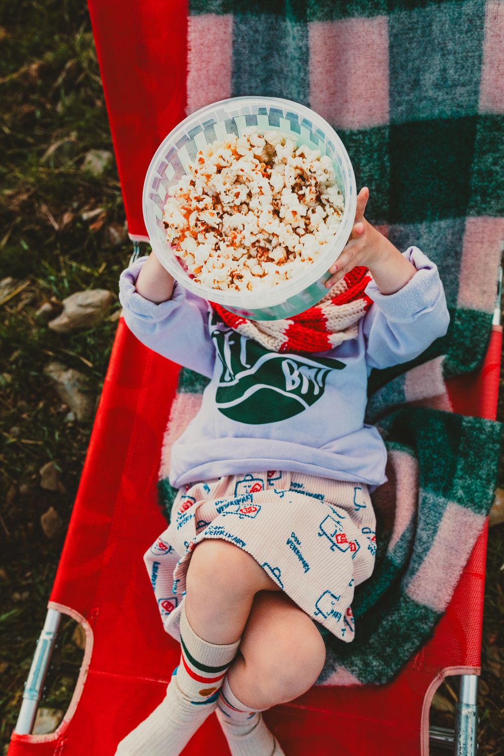 Fotografía de moda de niños niña estirada con popcorn en Barcelona