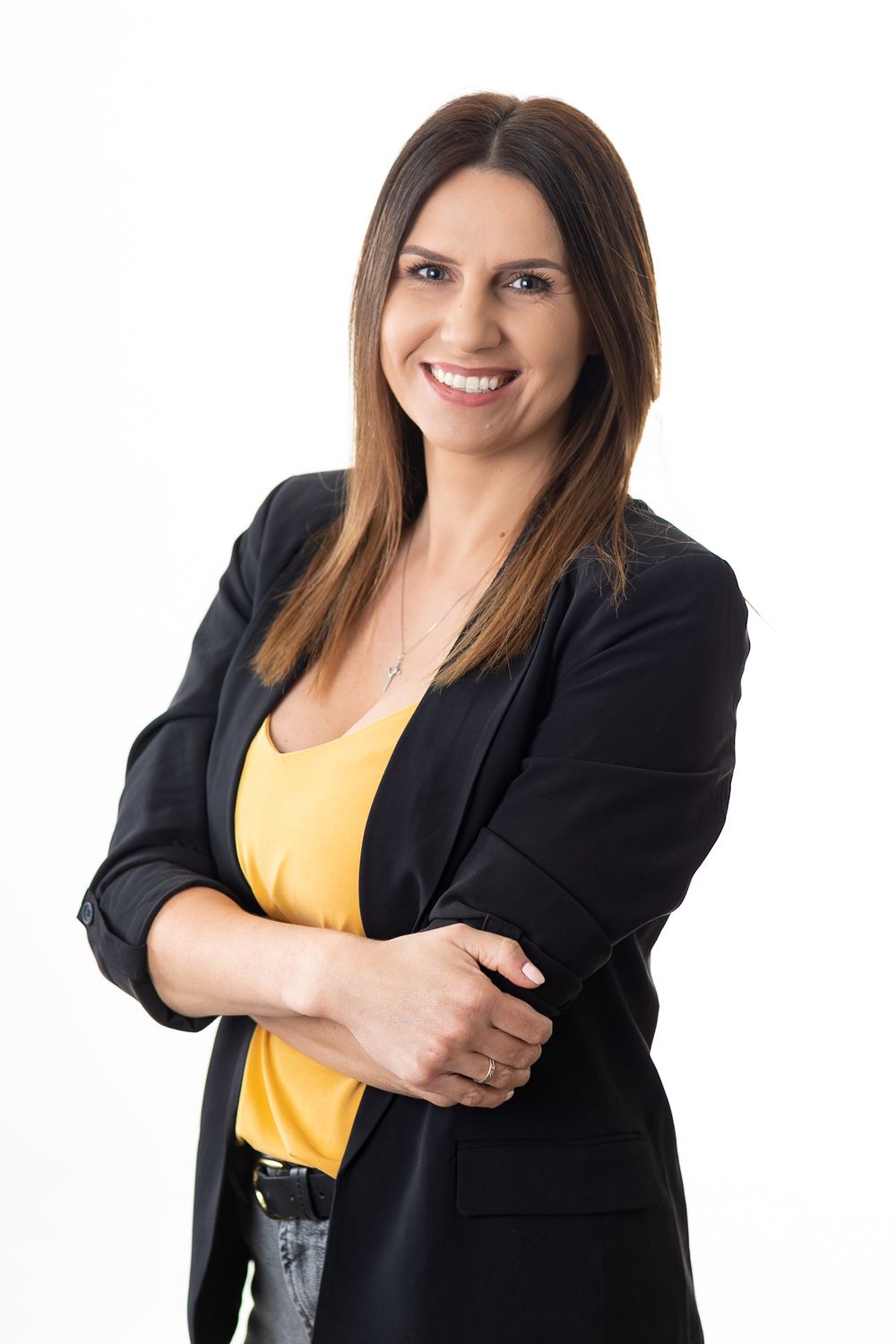 Professional business portraits showing person in black blazer and yellow top.