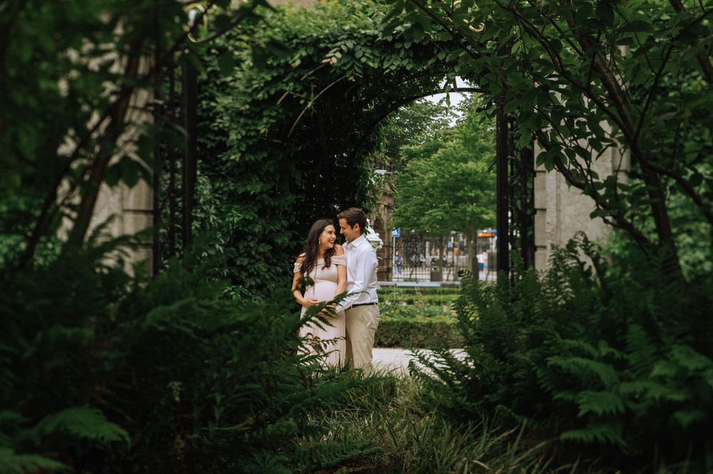Romantic photoshoot in a lush green garden setting with trees framing the scene.