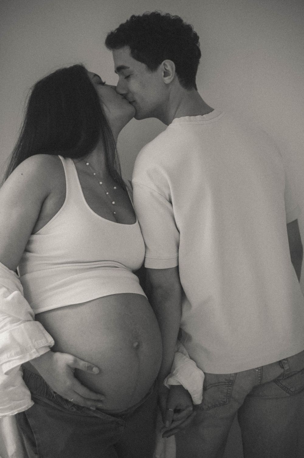 Black and white sequence showing an intimate maternity photoshoot with couple in white clothing.