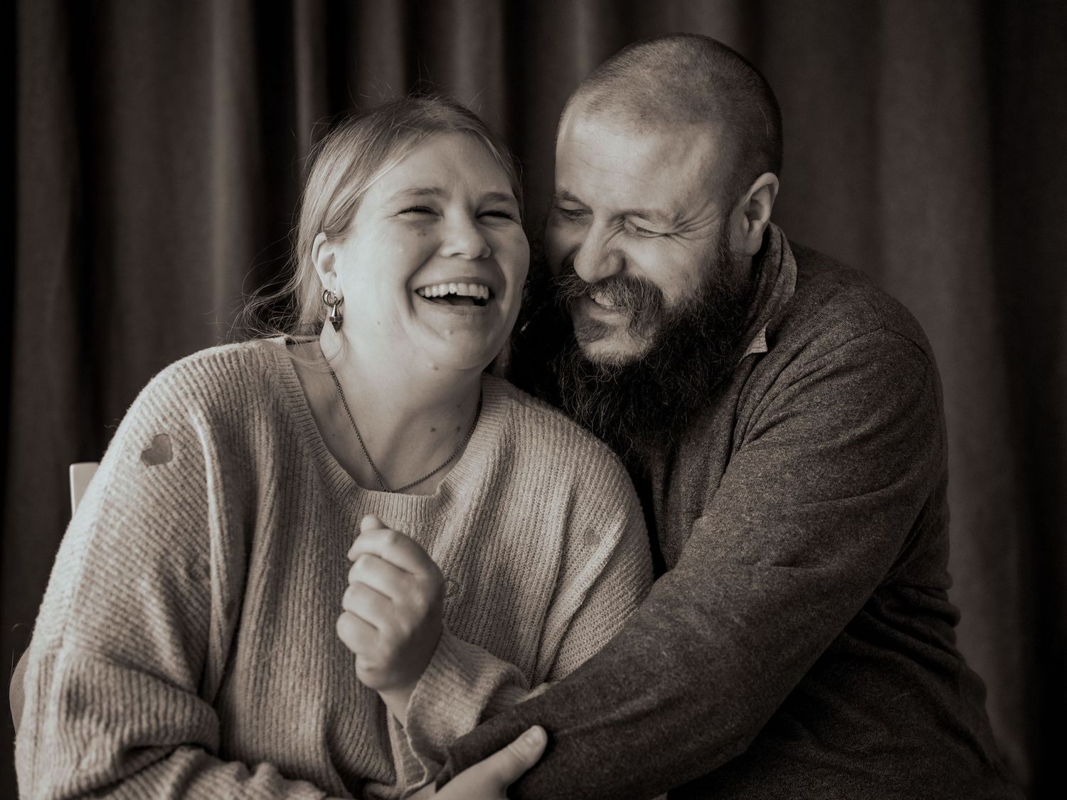 Parfotografering av Fotograf Jessica Lindqvist - porträtt av ett par som kramar varandra och skrattar.