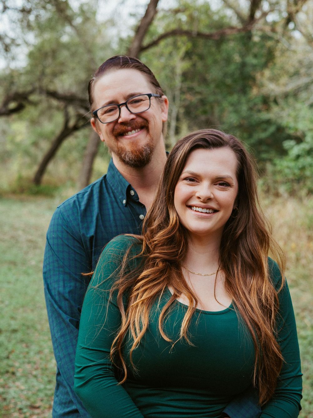 A warm and natural outdoor couples' portrait in a wooded Austin, Texas area, showcasing un-staged nuances.