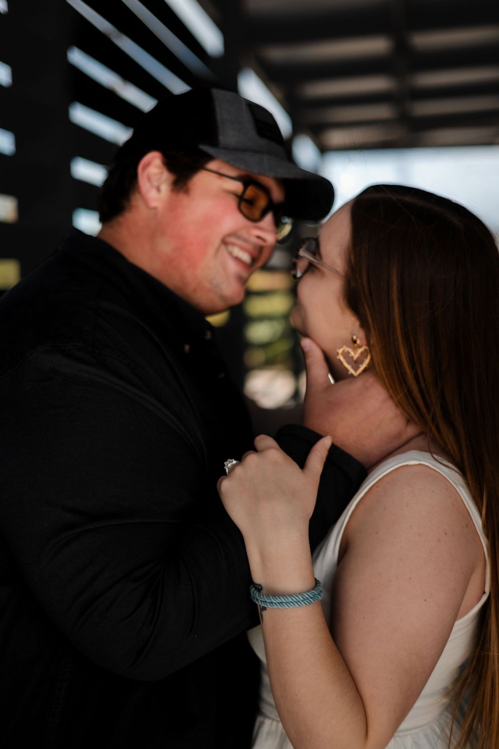 A candid, un-staged moment of a couple laughing and embracing during a sunset engagement session.
