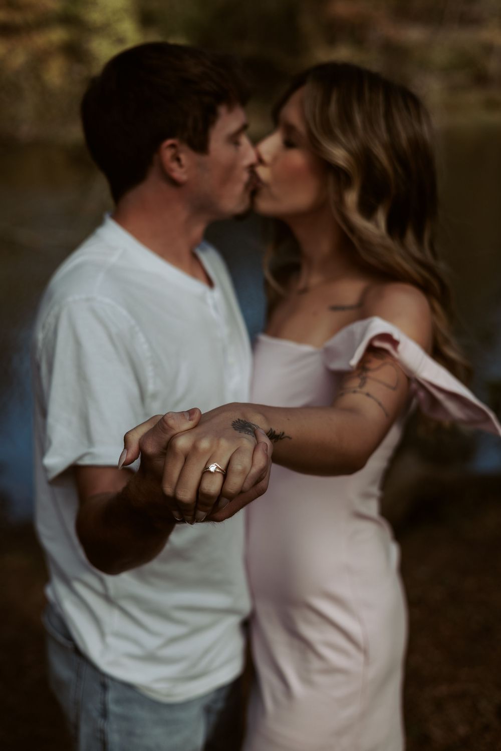 A close-up lifestyle portrait of a couple kissing in soft natural light, capturing genuine nuances and emotion.