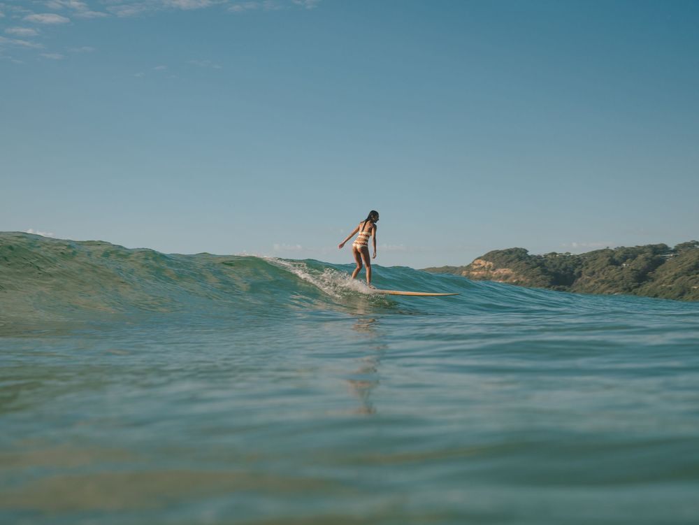 Girl dropping in on a wave with Sunlight surfers Newcastle women's surfing group at Dudley