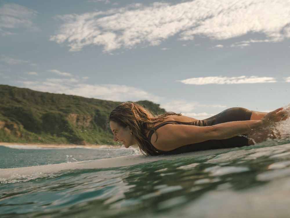 Girl missing the wave and laughing on a wave with Sunlight surfers Newcastle women's surfing group at Dudley