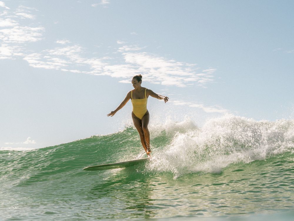 photo of a girl cross stepping on a critical wave on a group social surf with Sunlight Surfers Dudley Newcastle NSW