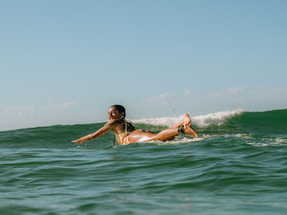 happy female surfer in Climax Surf Wax tankini on Sunlight Surfers social surf Dudley Newcastle NSW