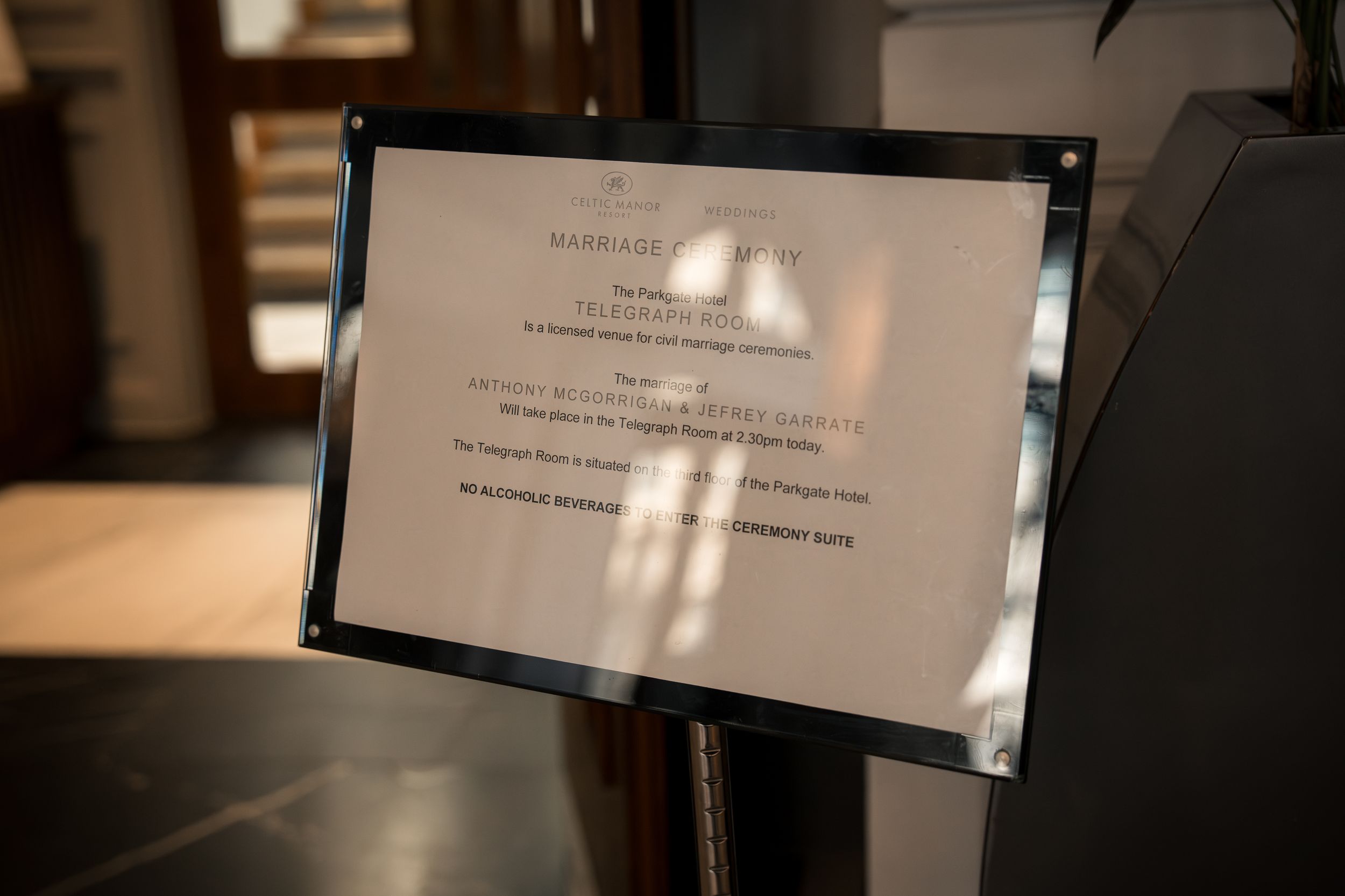 A framed marriage certificate displayed on a stand in an elegant venue setting.