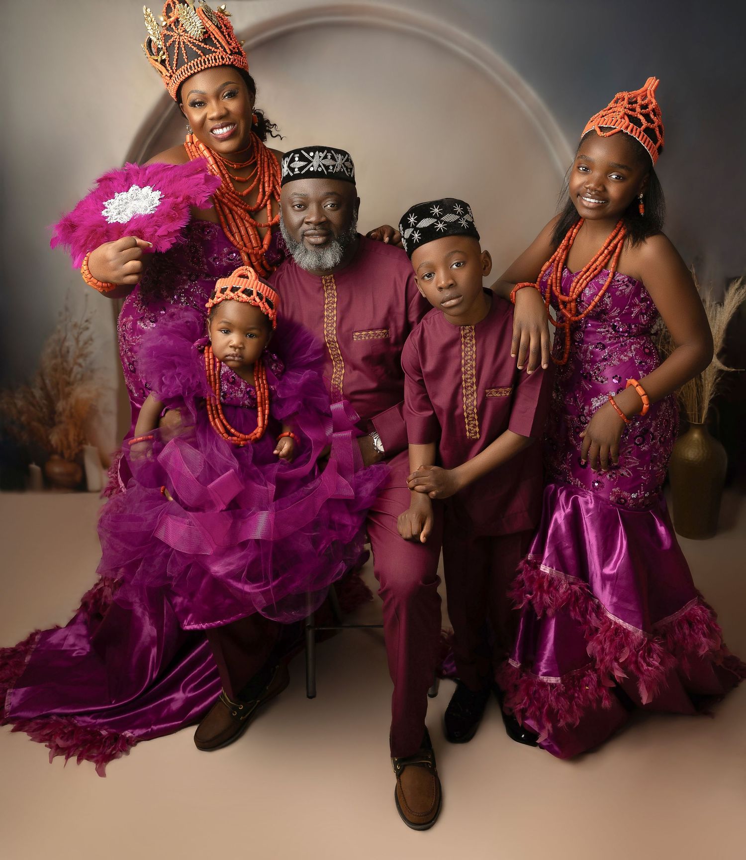 Family of five in matching purple traditional Nigerian attire with coral bead accessories. Vanessa Charlotte Photography  Wolverhampton