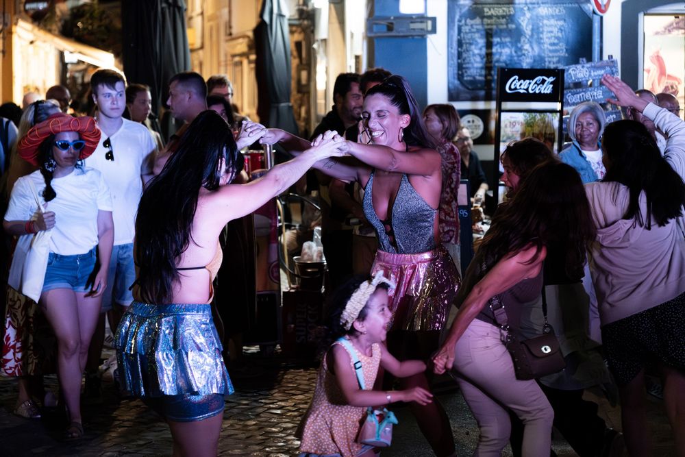 People dancing and socializing at a lively nightclub with a Coca-Cola sign in the background.