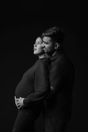 A dramatic black and white photo series showing two people in dark clothing embracing against a dark background.