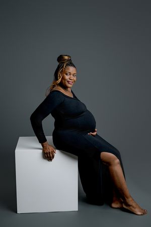 A series of artistic studio portraits showing someone in a black dress posing elegantly against a dark backdrop with a white cube.