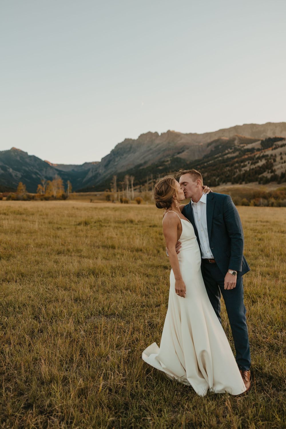 Couple kissing at sunset at Grizzly Creek Ranch Wedding in Emigrant Montana captured by Pray Montana Wedding Photographer in Mountains