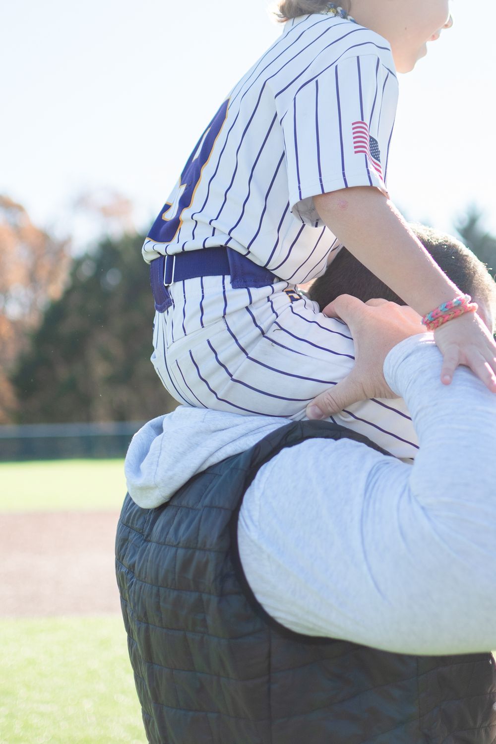 Close-up of baseball uniforms during outdoor practice session.