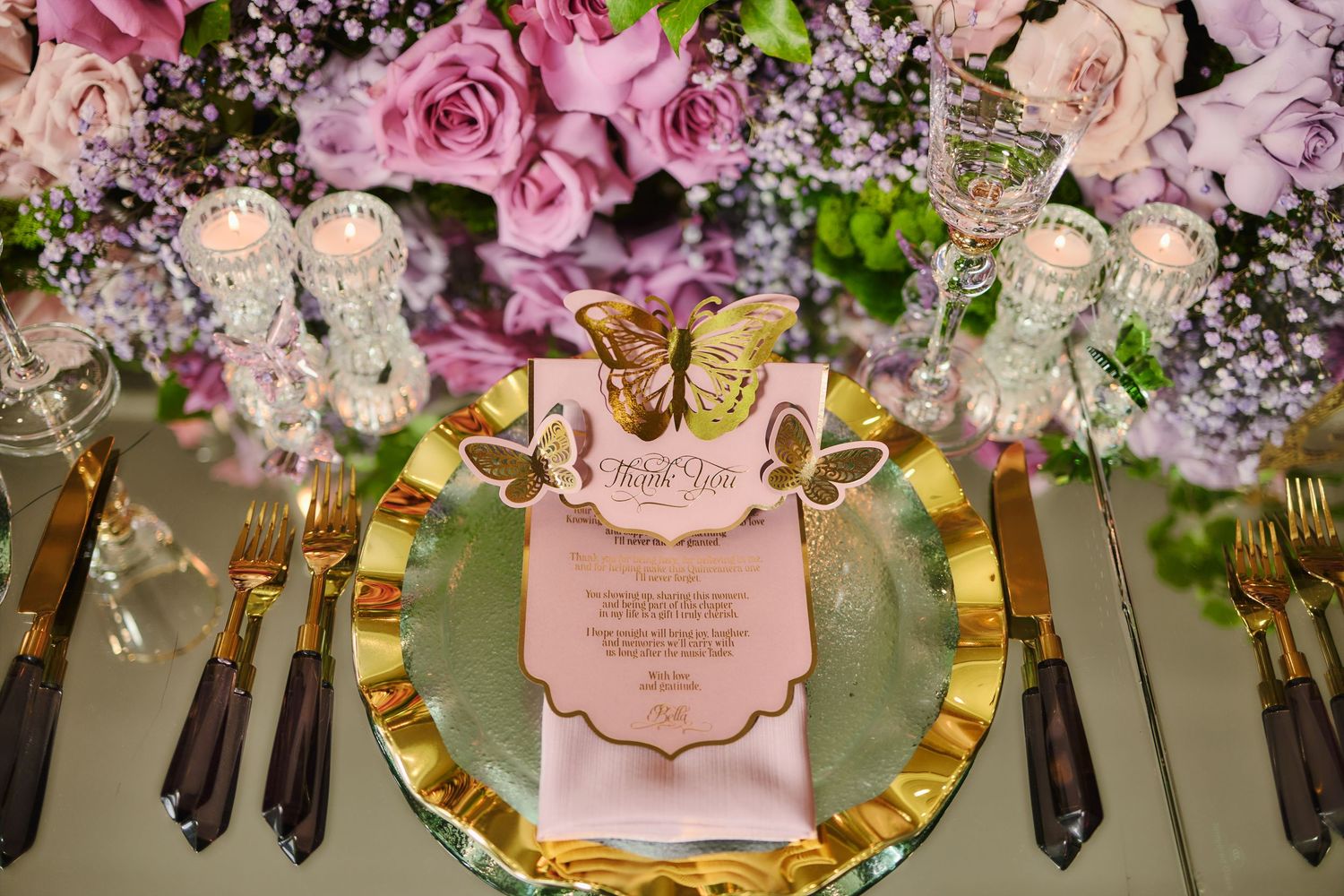 Elegant place setting with pink roses, gold charger plate and crown menu card on a decorated dining table.