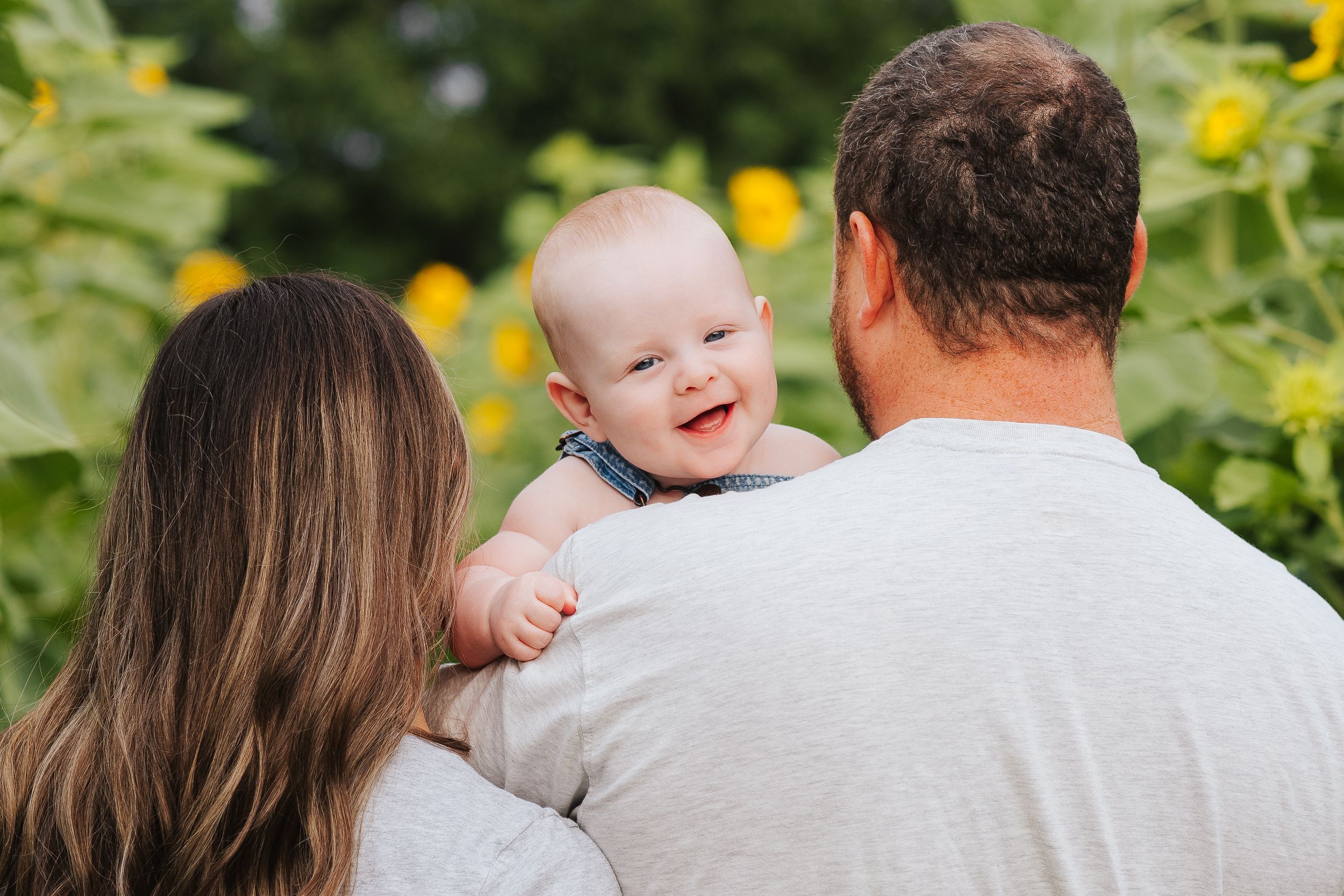 Happy family moment captured in blooming sunflower field.