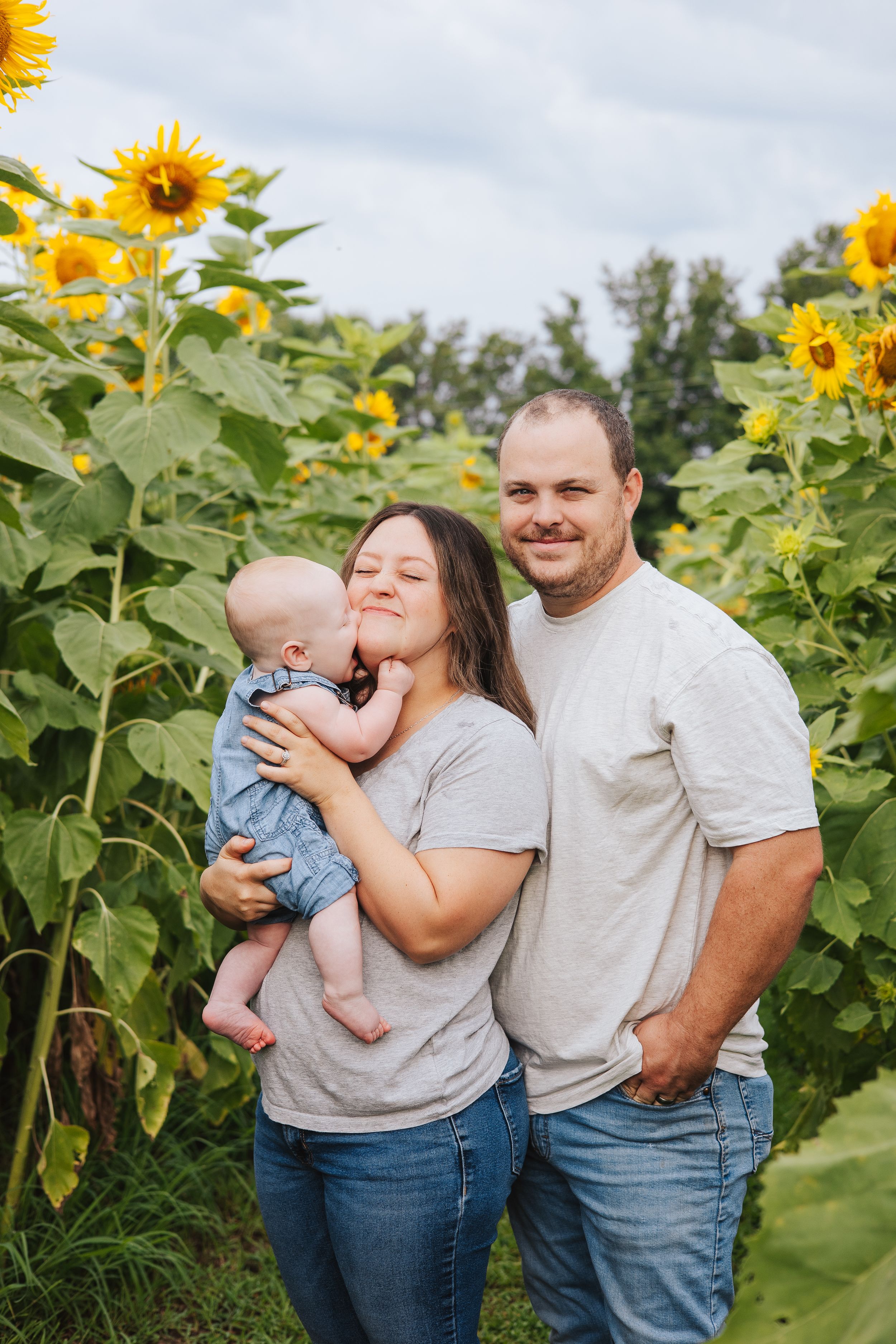 Family sharing joyful moment together among tall sunflowers.