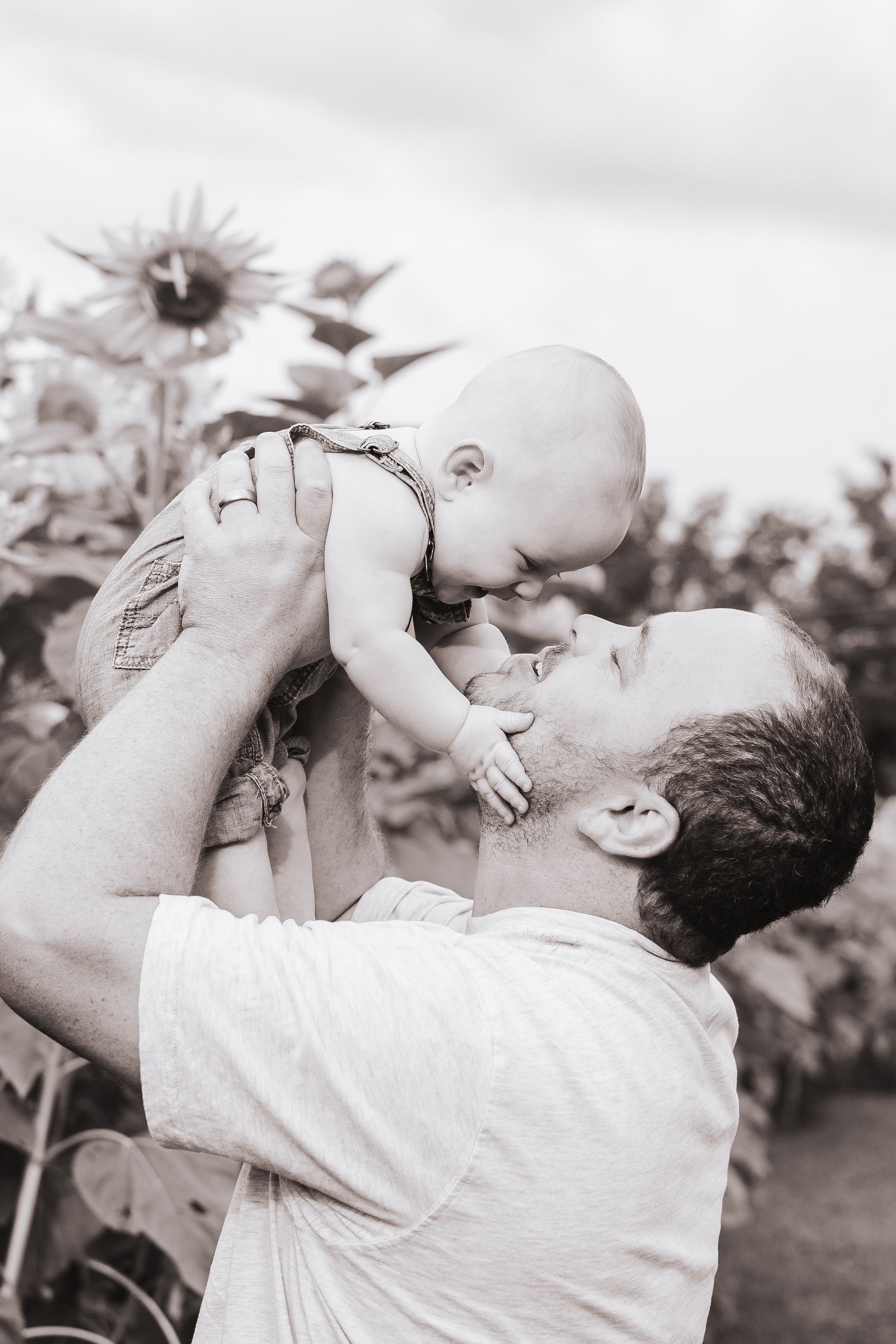 Black and white photo of joyful parent-child moment outdoors.