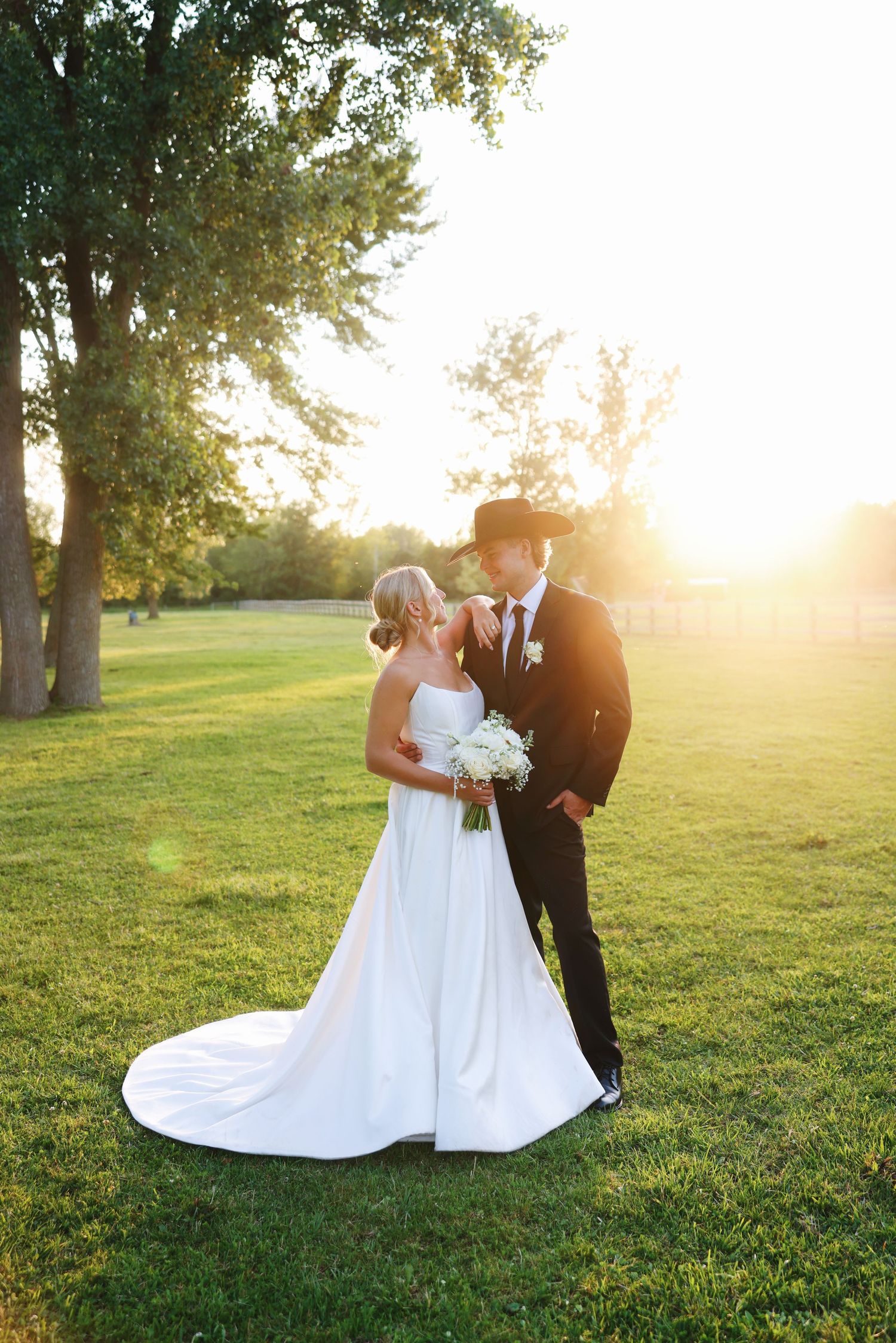 Elegant wedding couple poses on brick steps in formal attire.