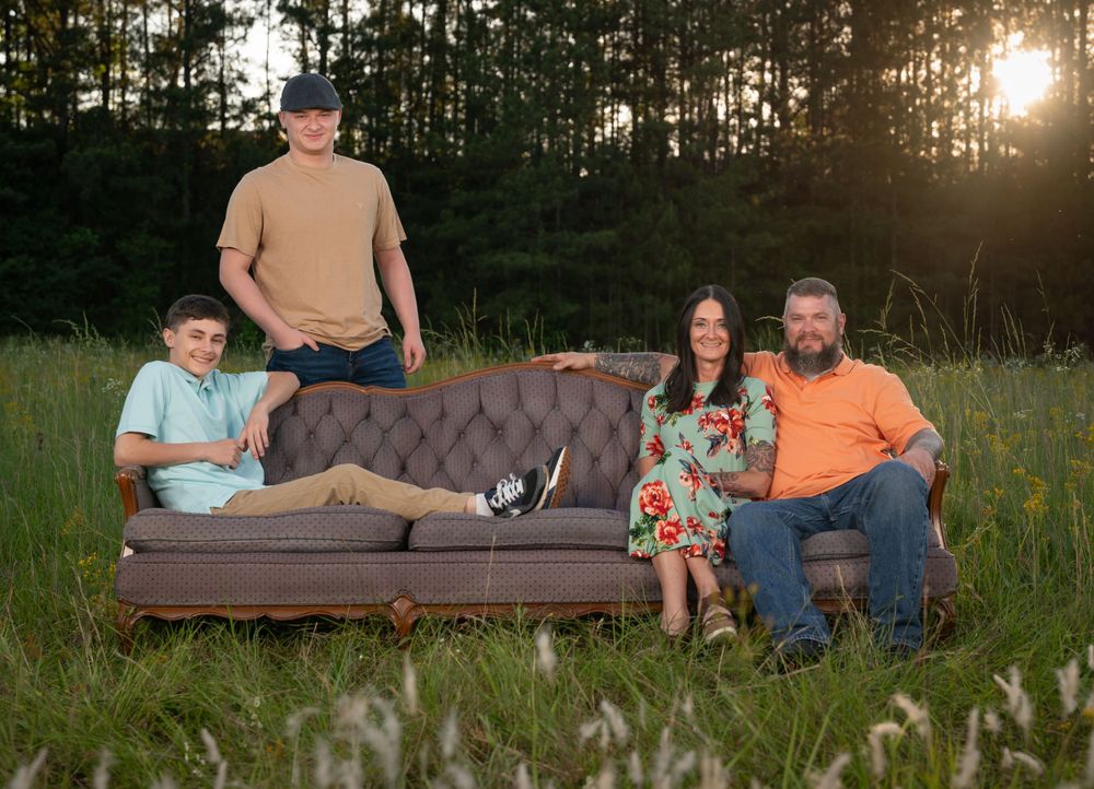 fun family portrait on a couch in a field