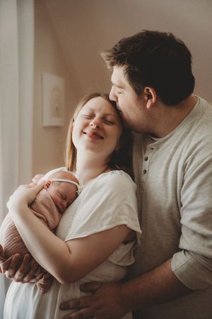 Gentle family moments with newborn baby in soft natural lighting.