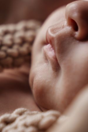 Extreme close-up series showing peaceful sleeping newborn's features in warm tones.