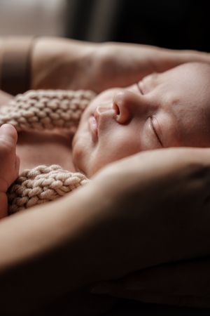 Artistic profile shots of sleeping newborn against textured knit blanket background.