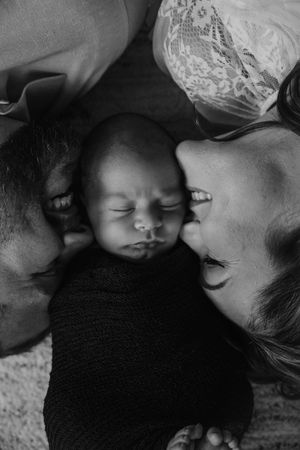Black and white series of intimate family moments with sleeping newborn.
