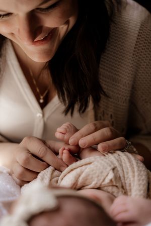 Intimate series showing tender moments between parent and newborn baby with soft lighting.