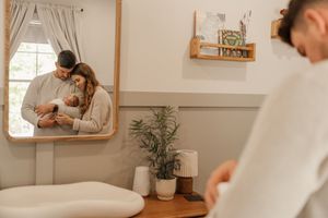 Interior view of a cozy nursery with wooden crib, plants, and neutral decor.